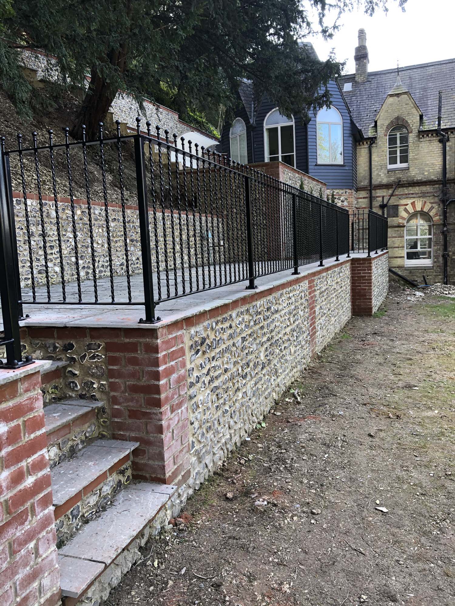 Wall with black metal fabrication fence